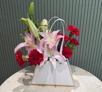 2 stem lilies + 6 read carnition pepar bage